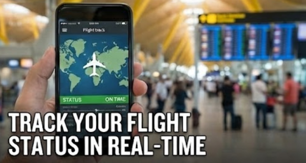"Traveler holding a smartphone showing live flight status and tracking map at a busy airport terminal."